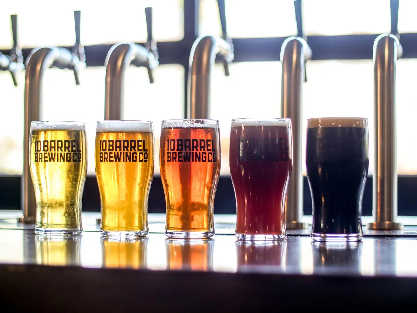 A row of branded beer glasses filled with craft beer