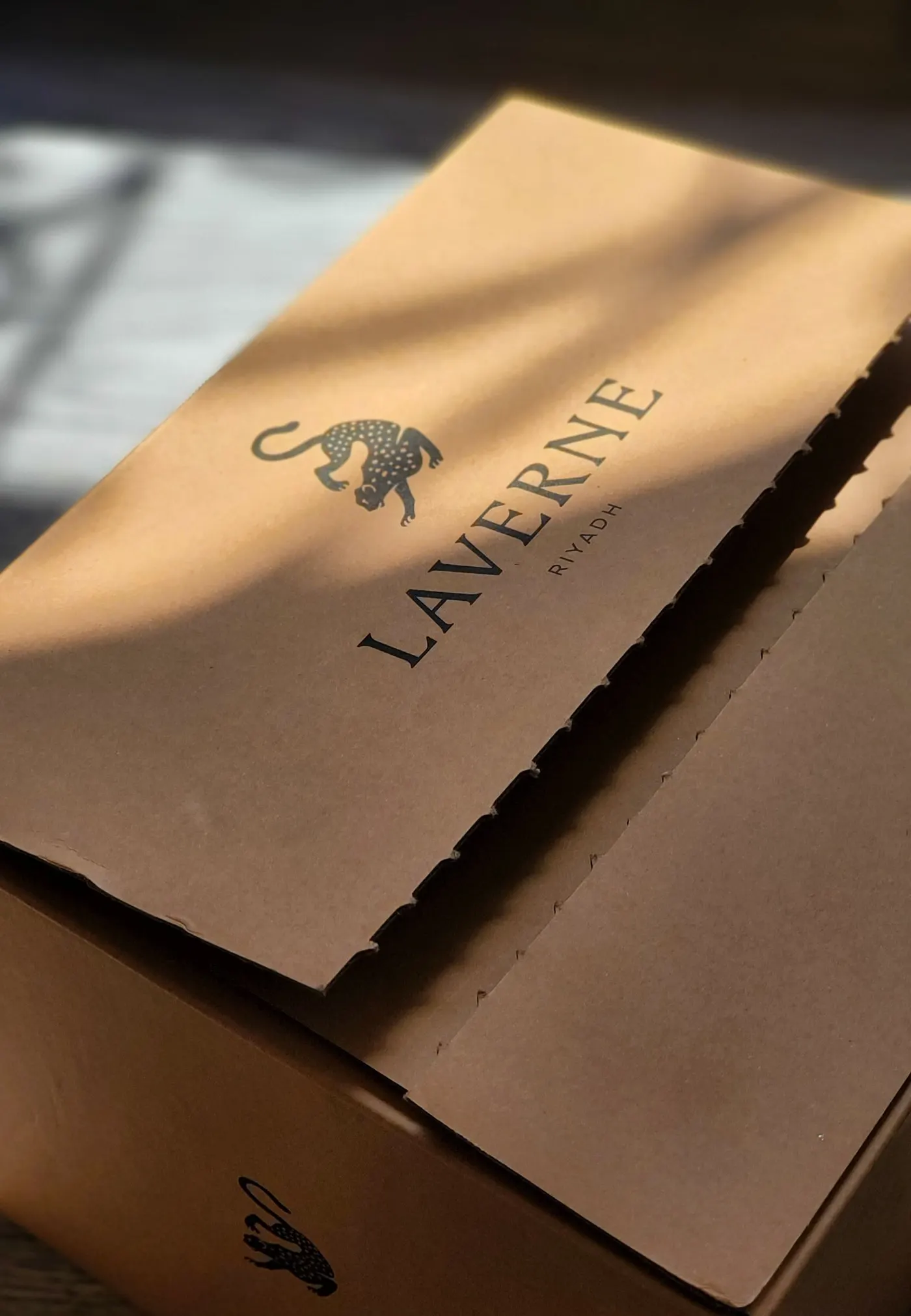 A kraft mailer box printed with a brand logo