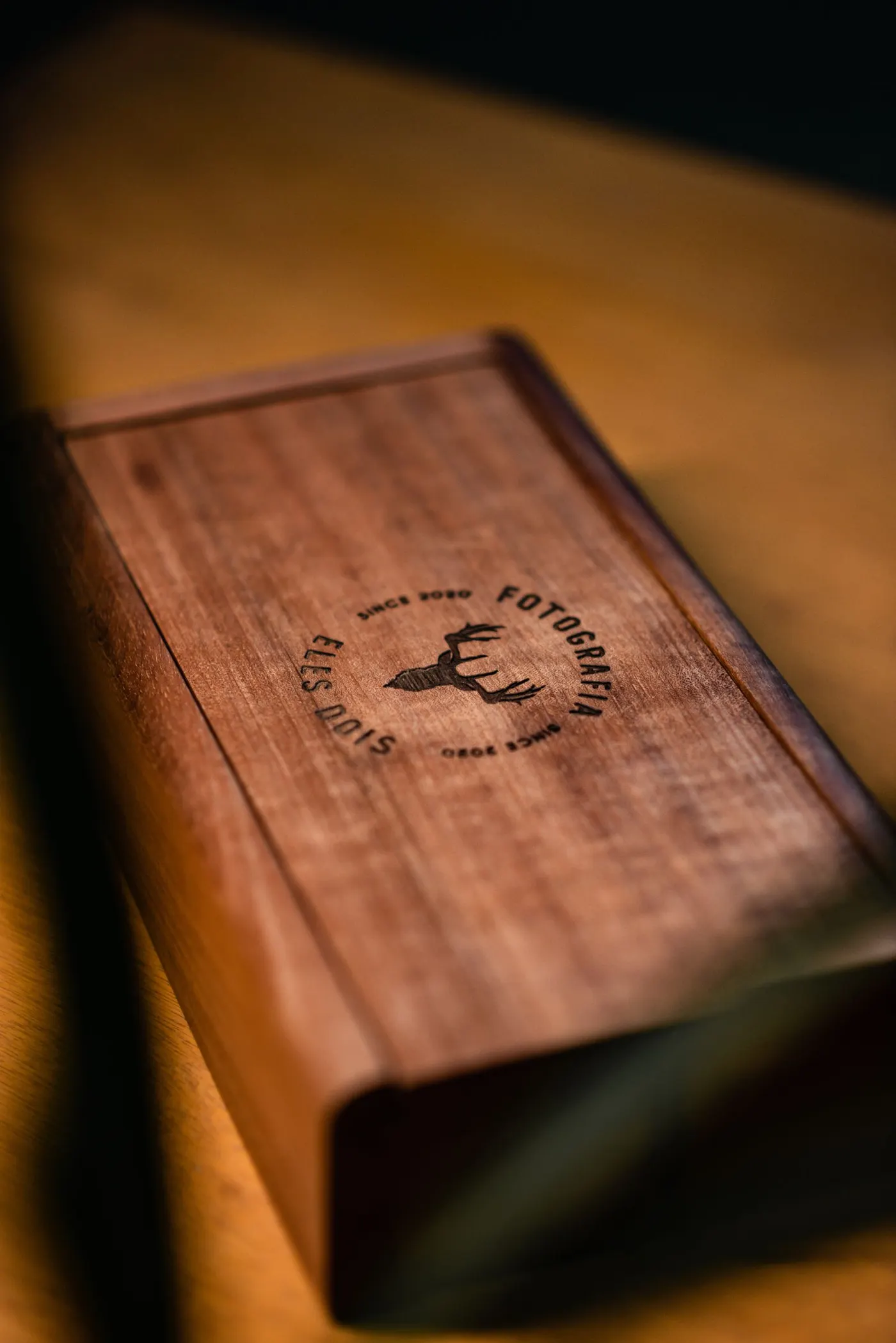 A wooden box with an engraved logo