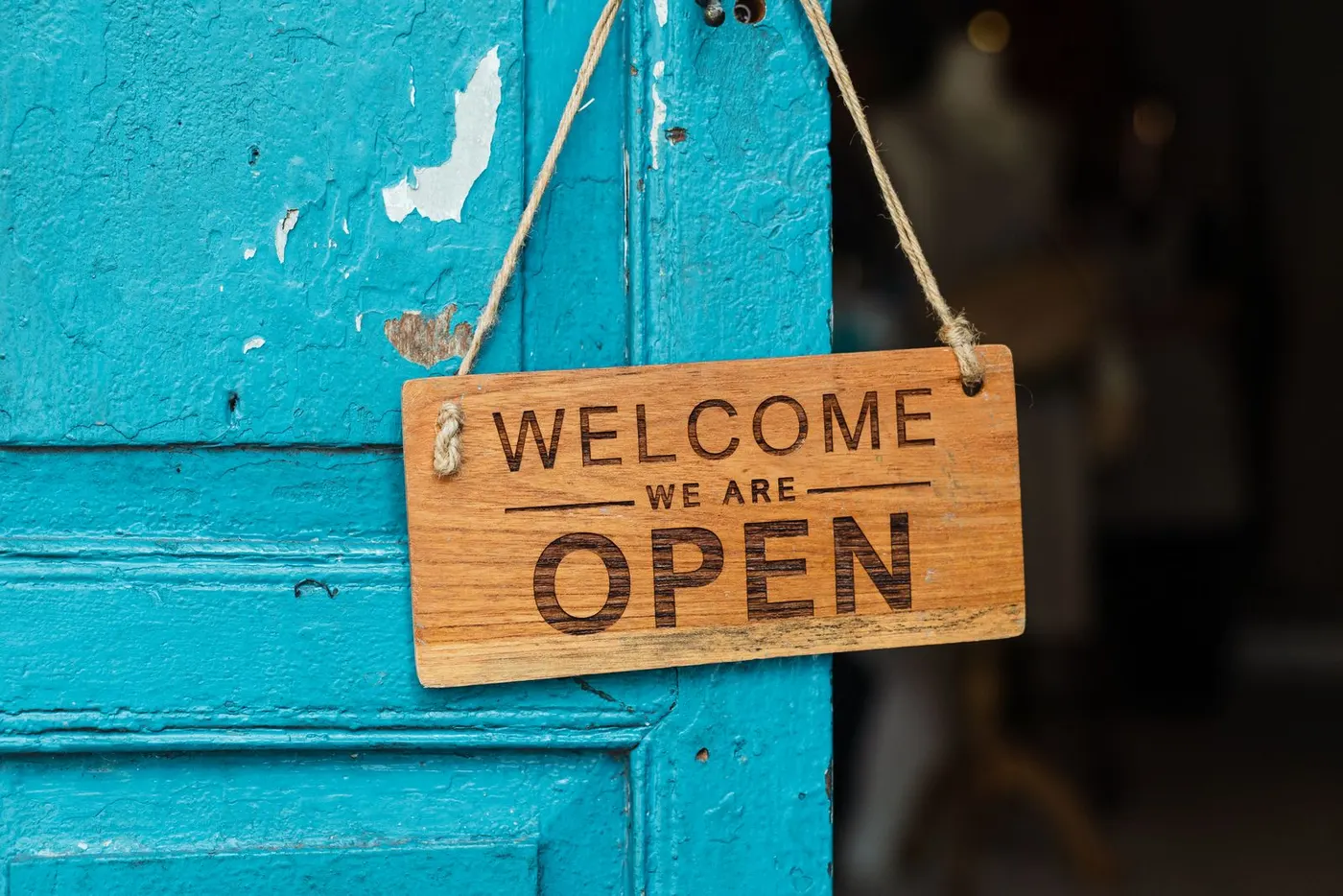 A rustic painted wooden welcome sign